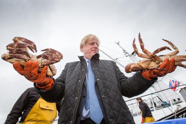 英国首相鲍里斯·约翰逊在参观苏格兰高地和北岛时，在斯特罗姆内斯港抓螃蟹。